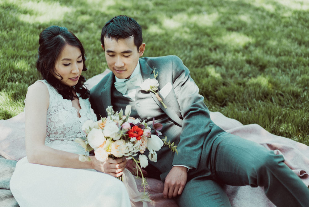 Bride and groom laying on grass at Piedmont Community Hall wedding