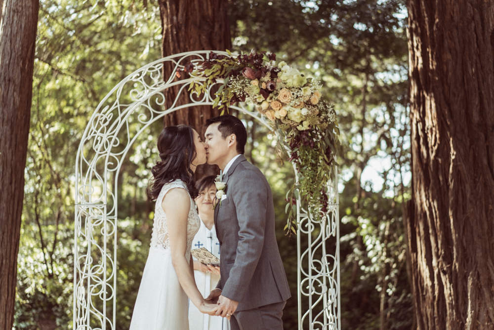 Bride and groom kiss during ceremony at Piedmont Community Hall wedding