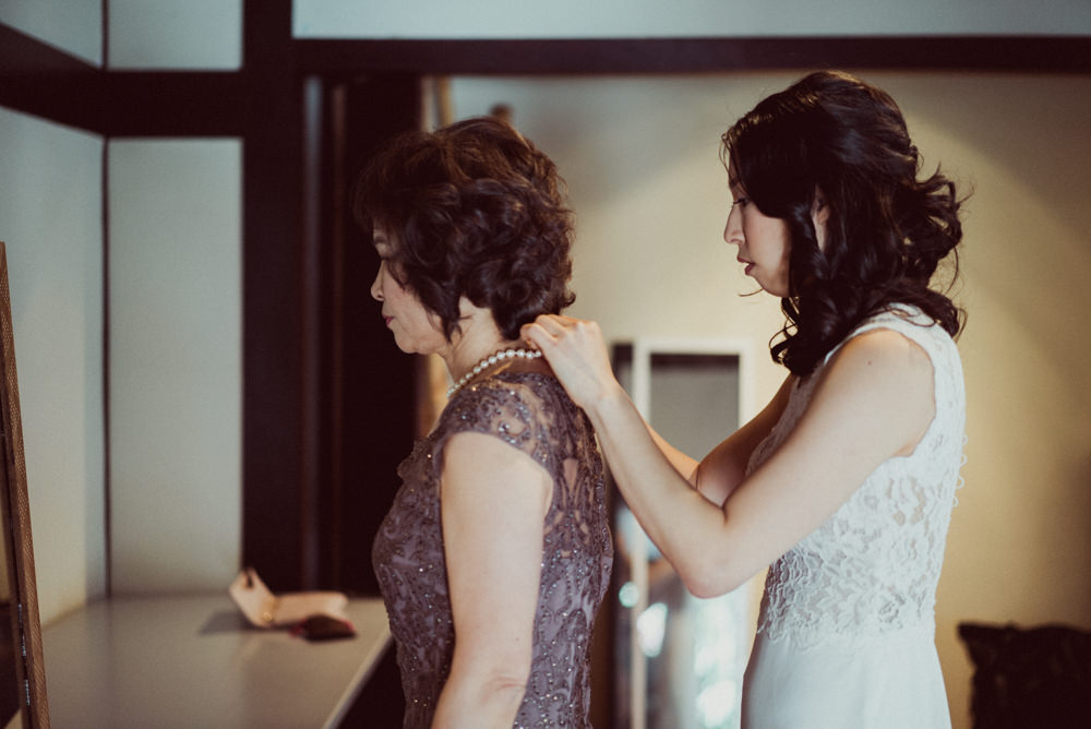 Bride helping mother with necklace at Piedmont Community Hall wedding