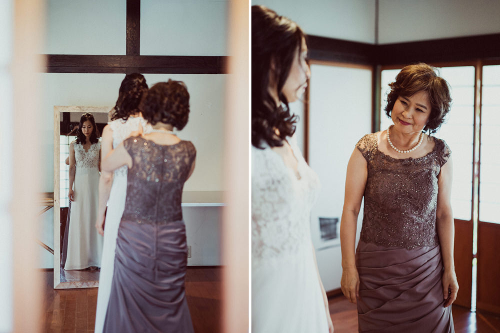 Mother helping bride put on wedding dress at Piedmont Community Hall wedding