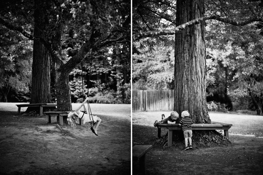 Black and white portrait of children playing on swings during wedding ceremony at Mountain Terrace