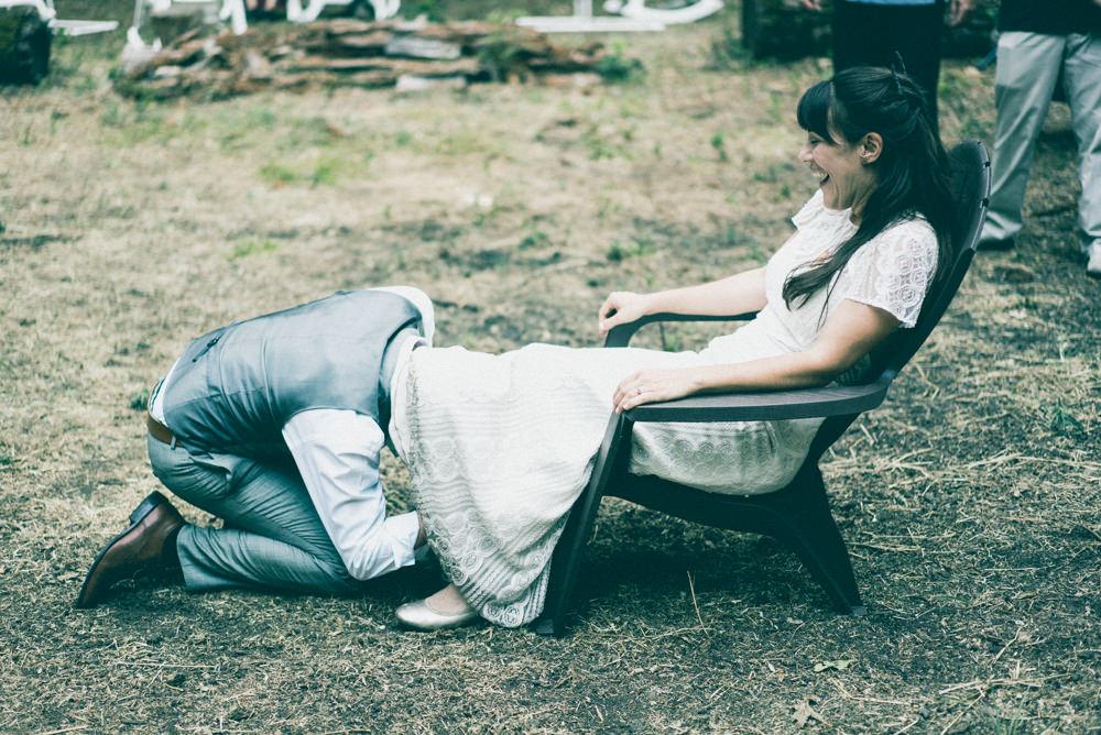 Groom crawling under bride's dress during garter toss grab