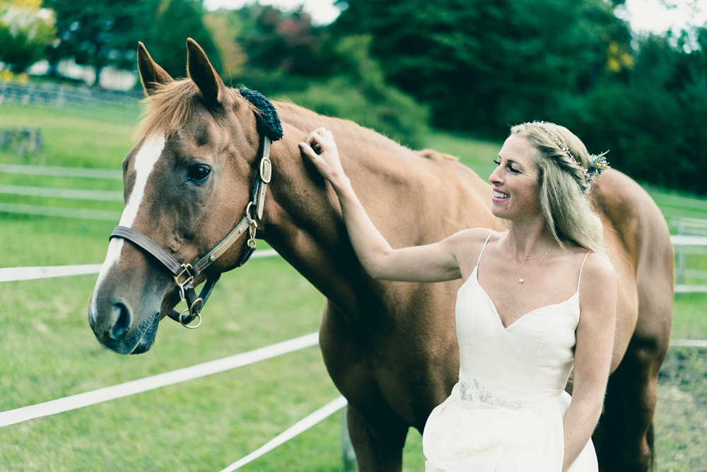 Bride with her horse before wedding in Vermont