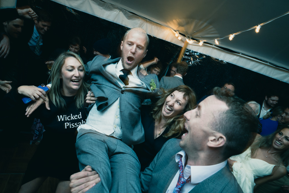 Crazy wedding shot of groom being carried by Wicked Pissah girl