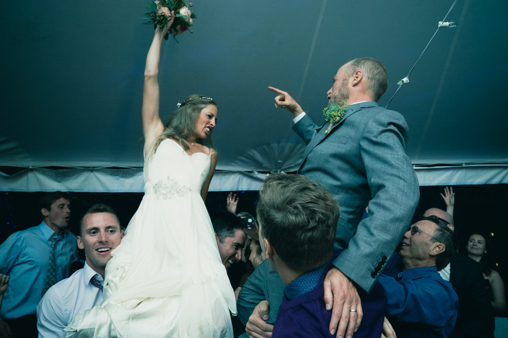 Bride and groom being carried up crazy dance shot