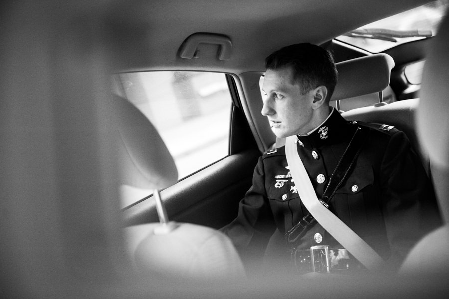 Black and white photo of groom reflecting in car on wedding day