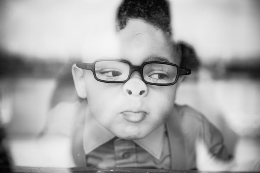 black and white candid portrait of child through window