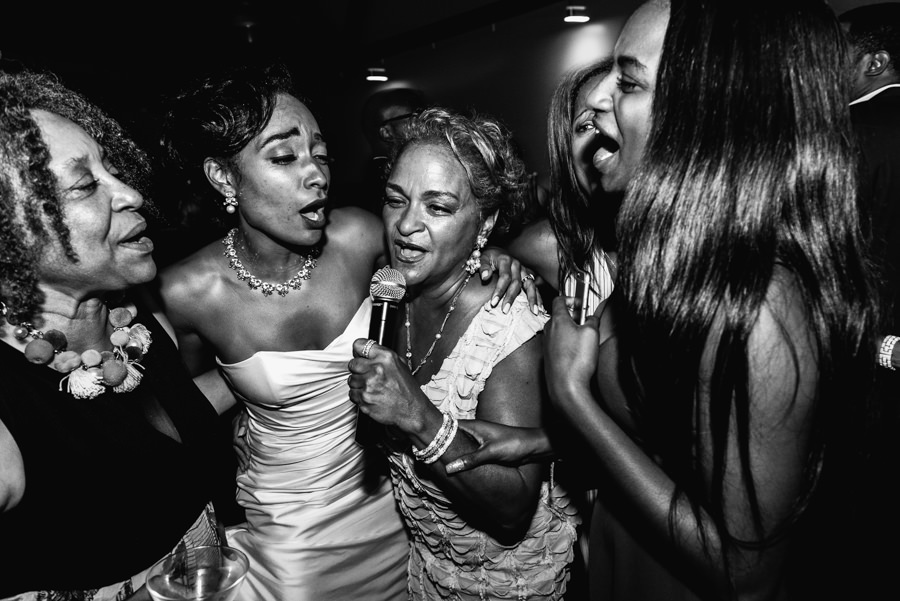 black and white candid shot of bride and mother singing and dancing