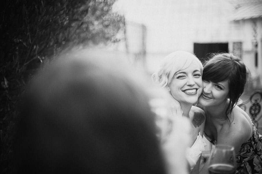 Black and white candid portrait of bride and her friend posing for a picture at Conservatory of Flowers wedding